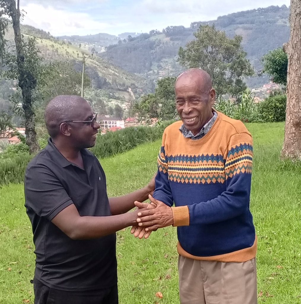 Head of Public Relations and Spokesperson for the Electoral Commission, Mr Julius Mucunguzi having a handshake with Mr Tindyebwa, a Consultant Trainer and English News Anchor at Voice of Kigezi – Kabale.